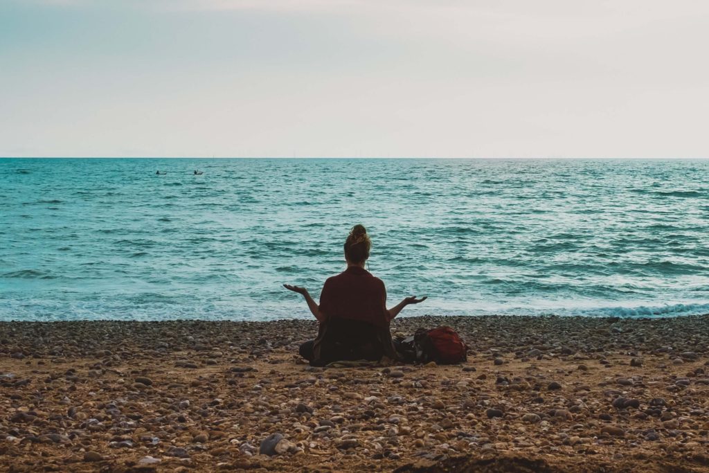 A woman meditating on the beach
